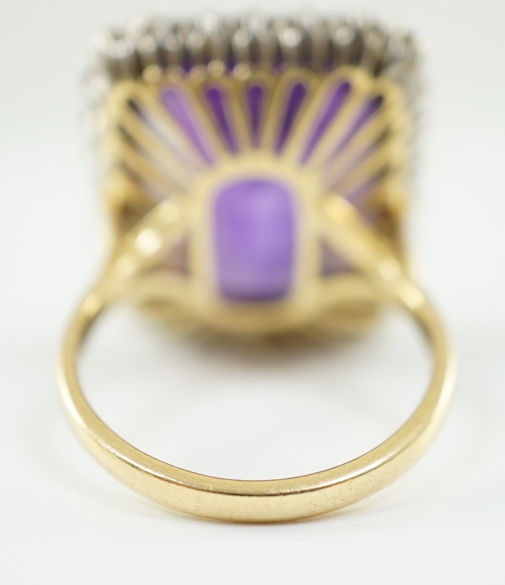 A large modern 18ct gold and emerald cut amethyst set dress ring, with diamond set border